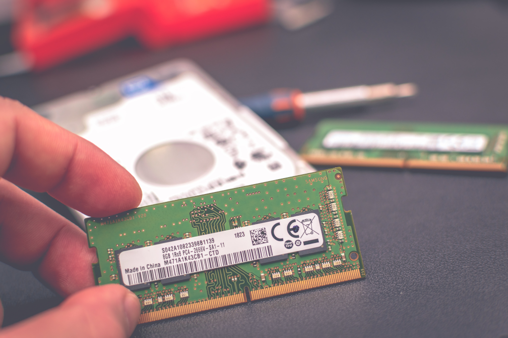 Close up image of computer RAM with additional pieces of computer hardware blurred in the background